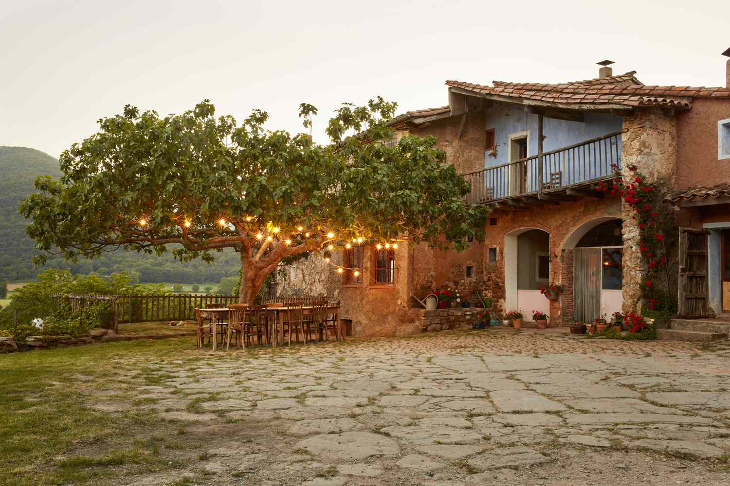 Villa com área de jantar ao ar livre e árvore com luzes de corda