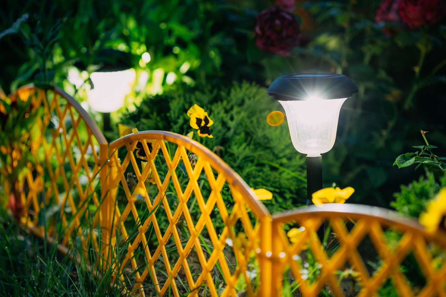 Luzes de estaca em um canteiro de flores